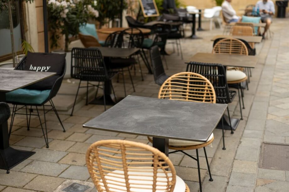 Ulica z krzesłami restauracyjnymi ustawionymi przy stolikach na świeżym powietrzu.